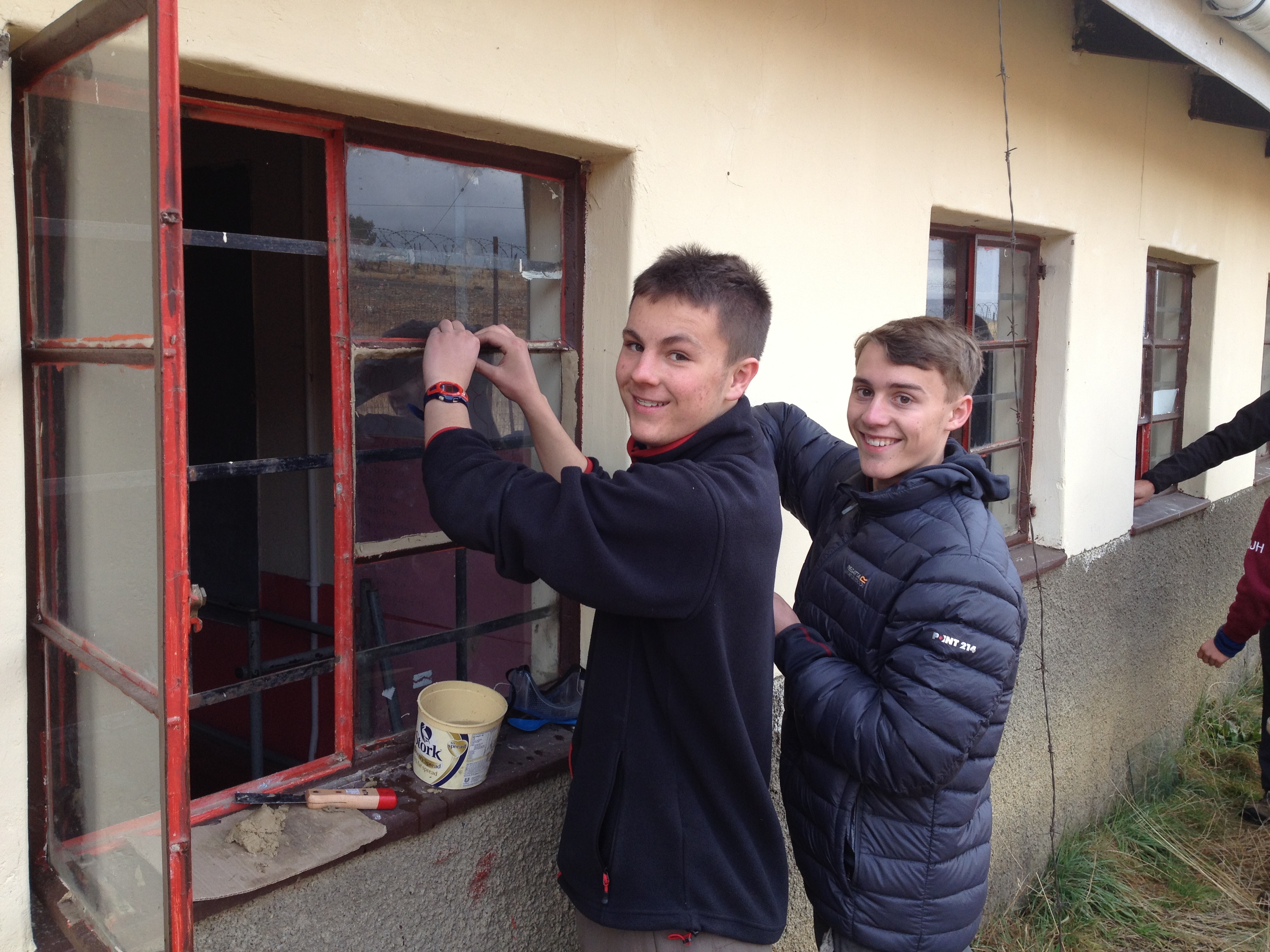 Ben Davis and Fraser Merrick replacing one of the 27 broken windows fixed by the group in a local school